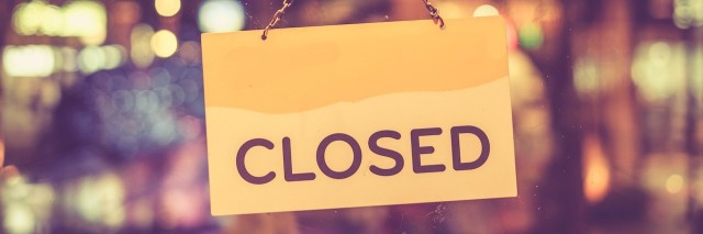 A closed sign hanging in a shop window
