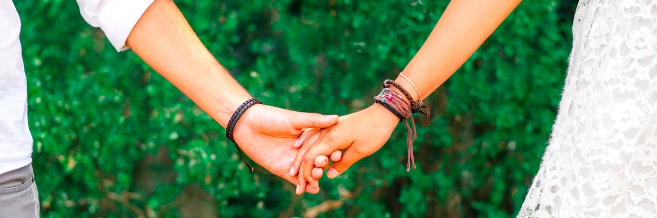 young couple holding hands in a park