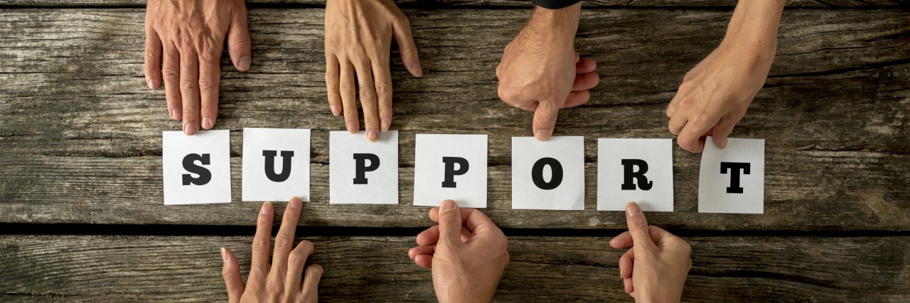 Advice for Someone Just Diagnosed With Marfan Syndrome Seven business people holding white cards with letters to assemble the word SUPPORT on textured wooden desk.