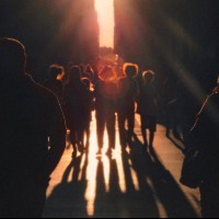 group of people walking towards light