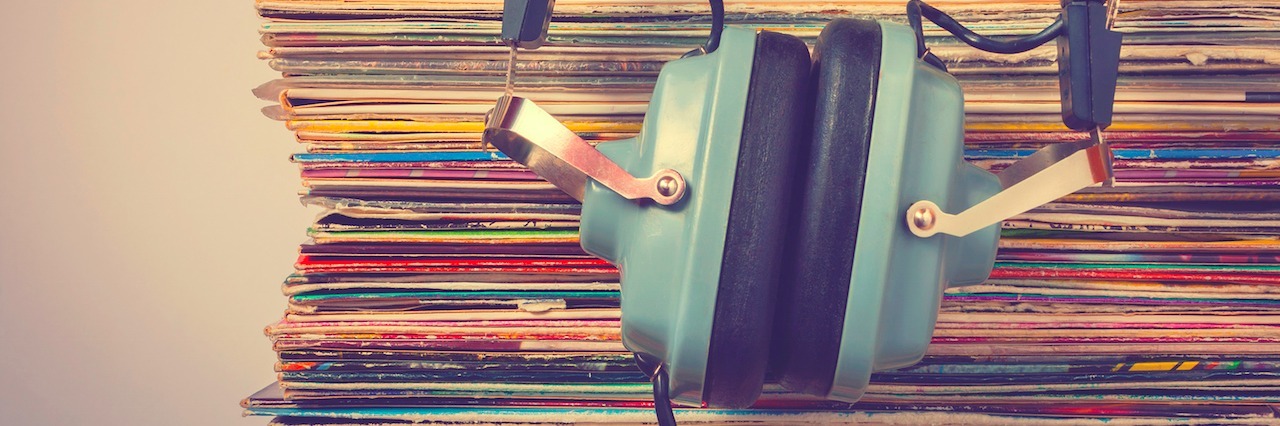 headphones leaned against a stack of albums