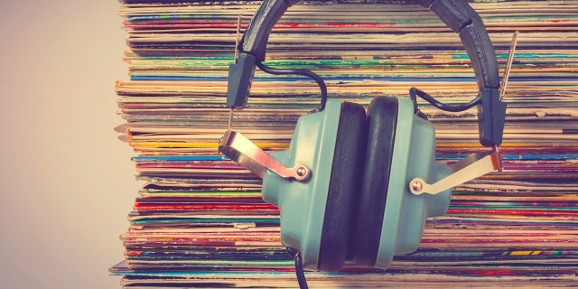 13 Songs That Make Life With Bipolar Disorder a Little Less Scary headphones leaned against a stack of albums