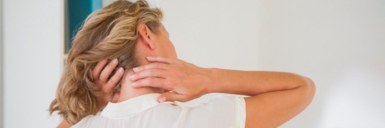 Life With One of the Most Painful Conditions Known to Modern Medicine Casual businesswoman rubbing her neck