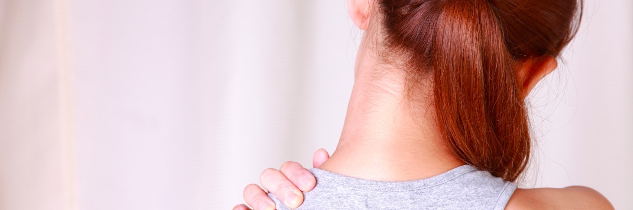 Ehlers-Danlos Syndrome: Two Types of Pain We Experience back view of woman rubbing top of shoulder