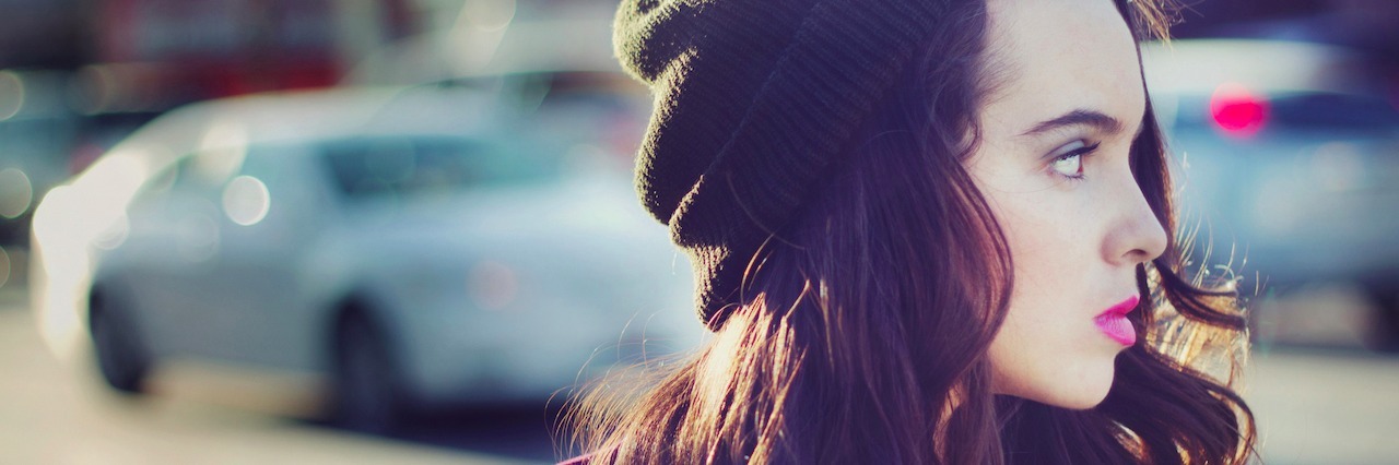 Acting Like a 'Chill Girl' to Cope With Mental Illness A woman standing in front of a street