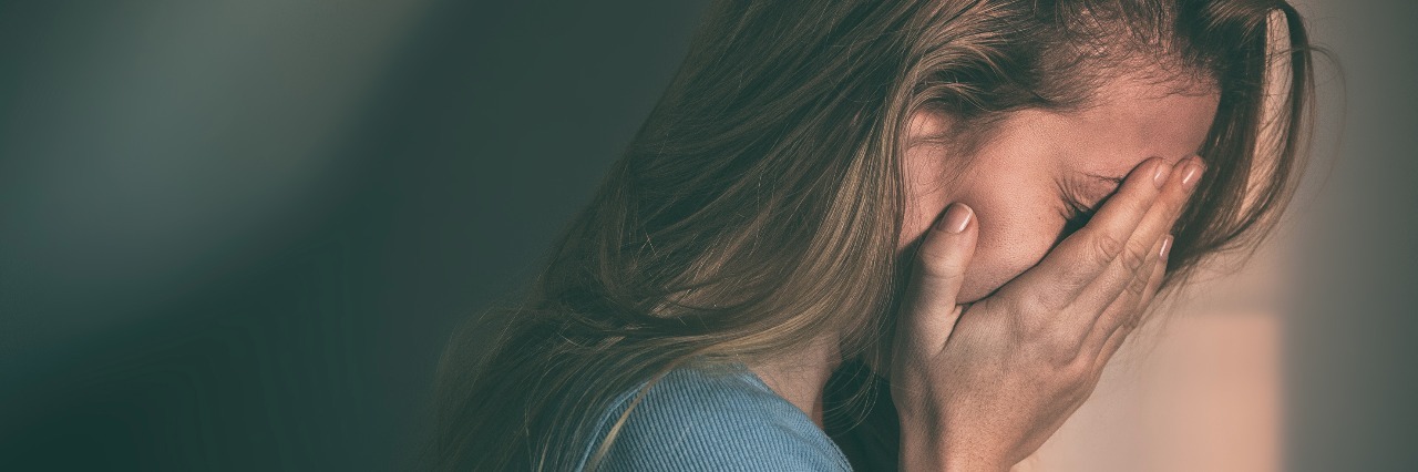 young woman with her head in her hands