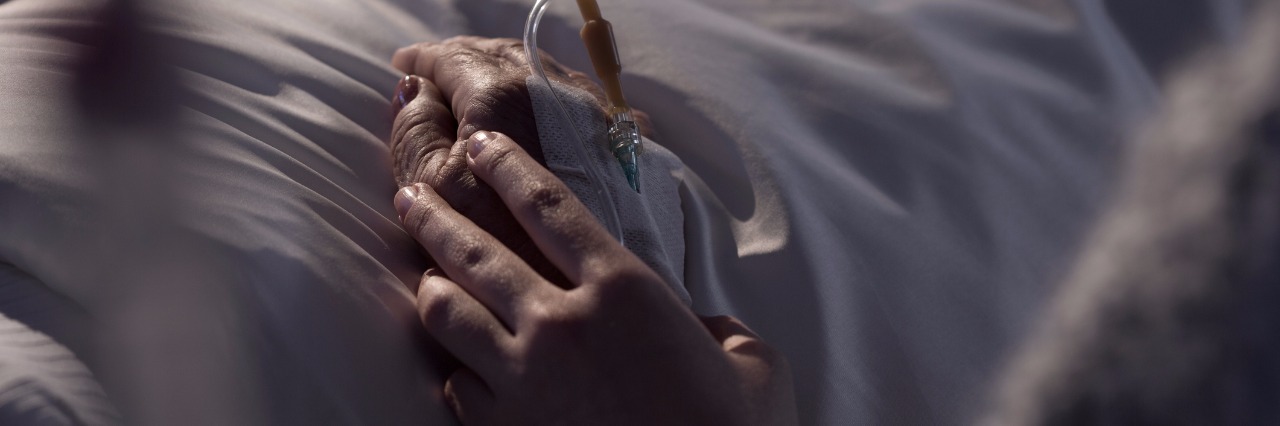 Bipolar Disorder: Grieving a Parent Who Had Mental Illness woman supporting dying mother in hospital bed