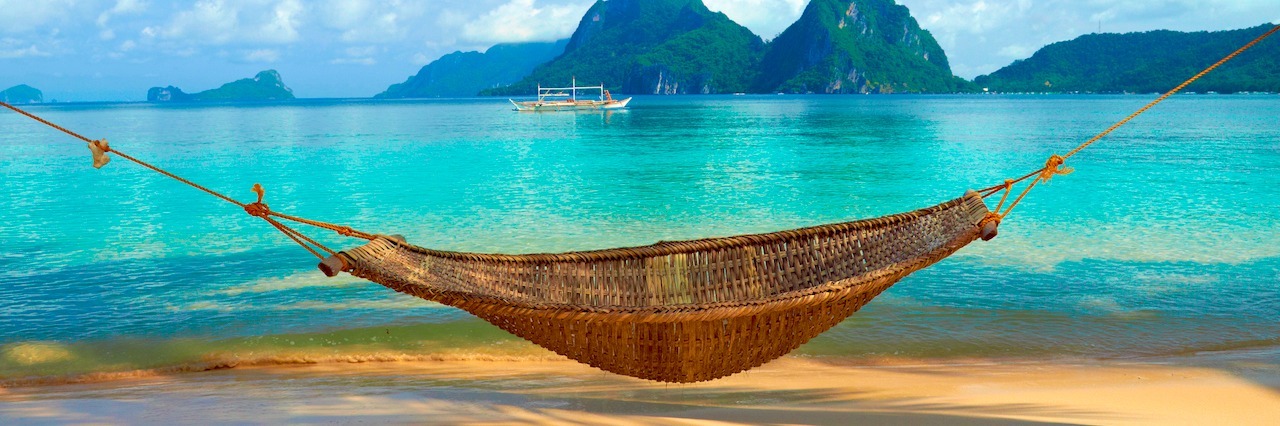 a hammock on a beach on a tropic island