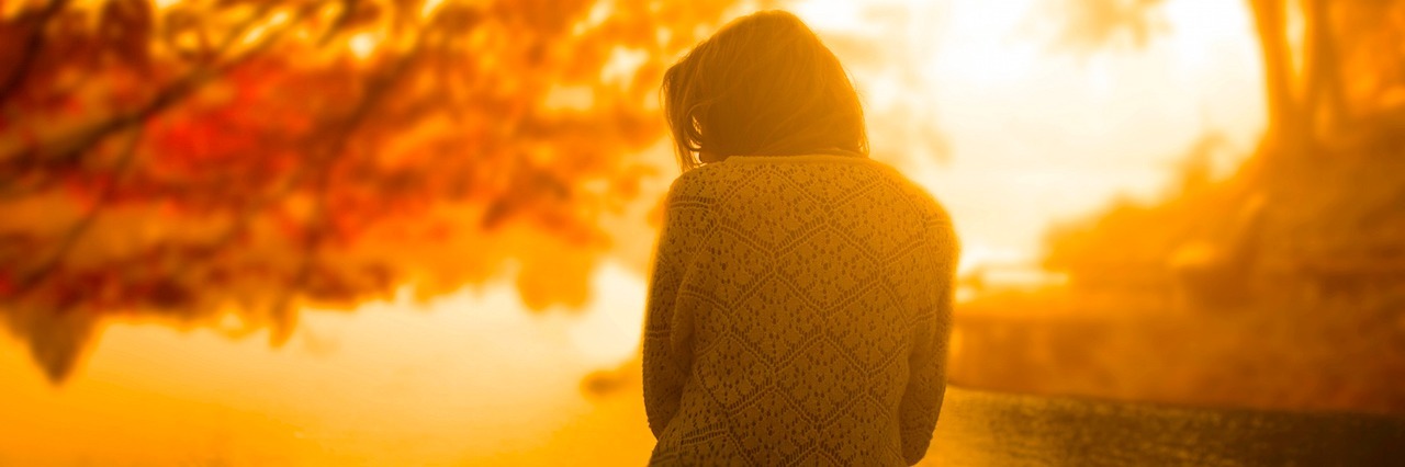 Bright Side of Depression and Anxiety woman sitting on a doc at sunset