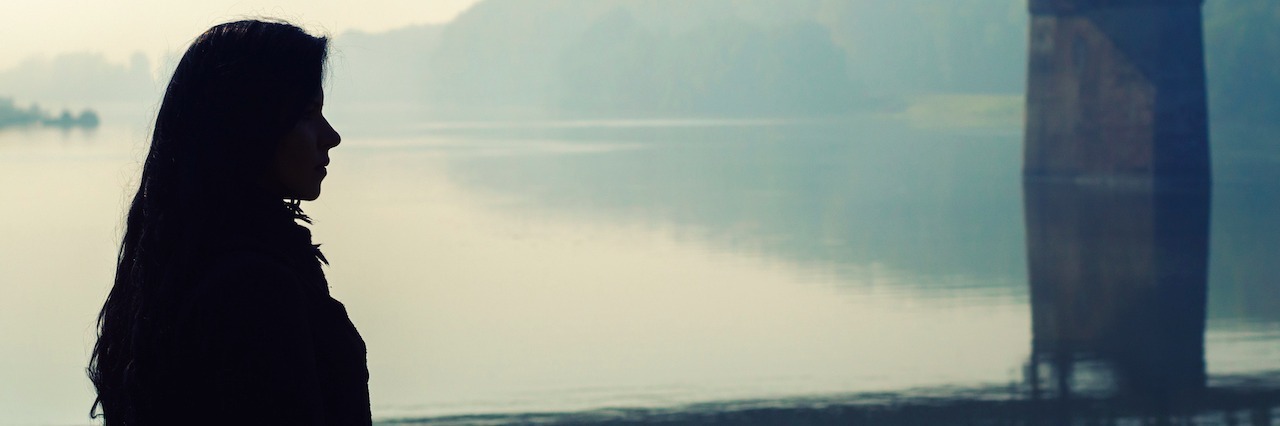 A Letter to the Person Struggling With Mental Illness Silhouette of beautiful girl standing on dock with bridge in background