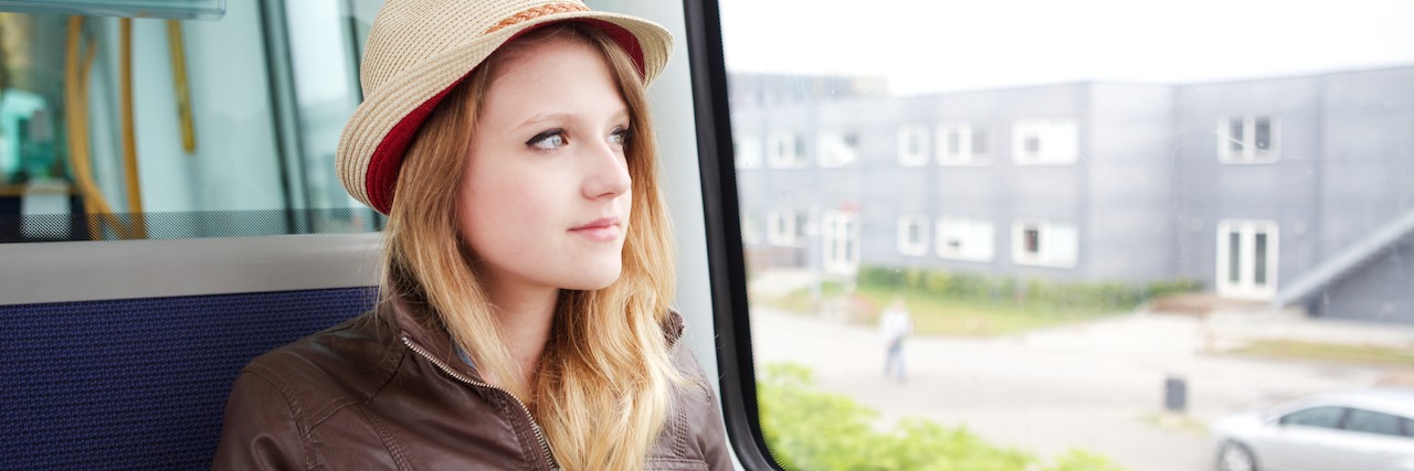 woman looking out her window on a bus