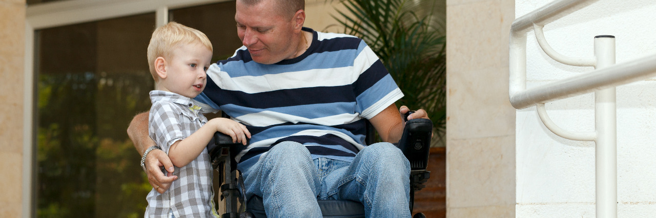 Dad who uses a wheelchair plays with child.