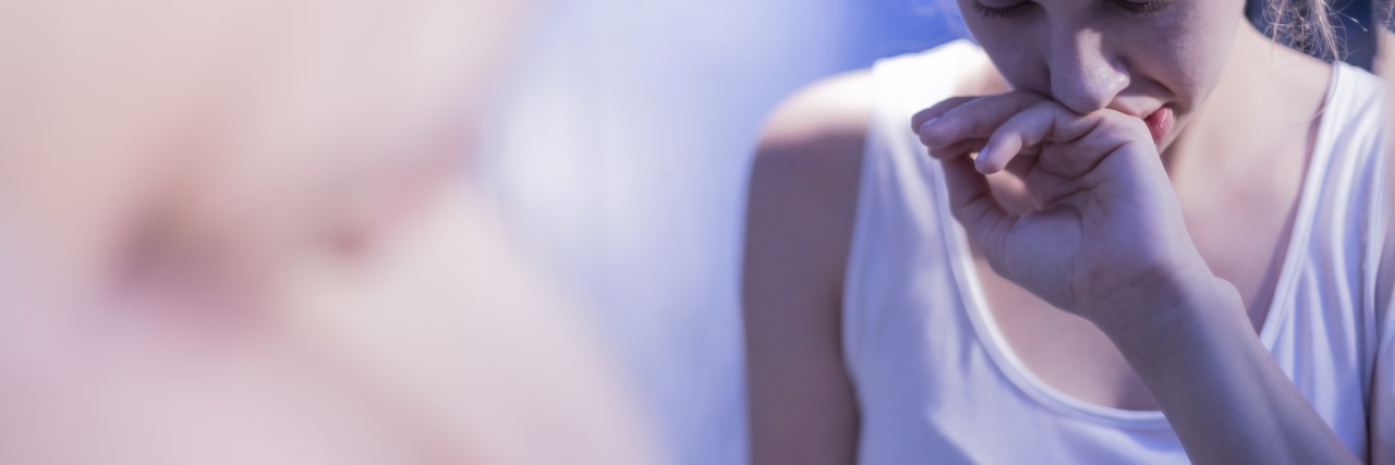 Working Through Body Image Issues After a Limb Amputation Sad woman in mirror.