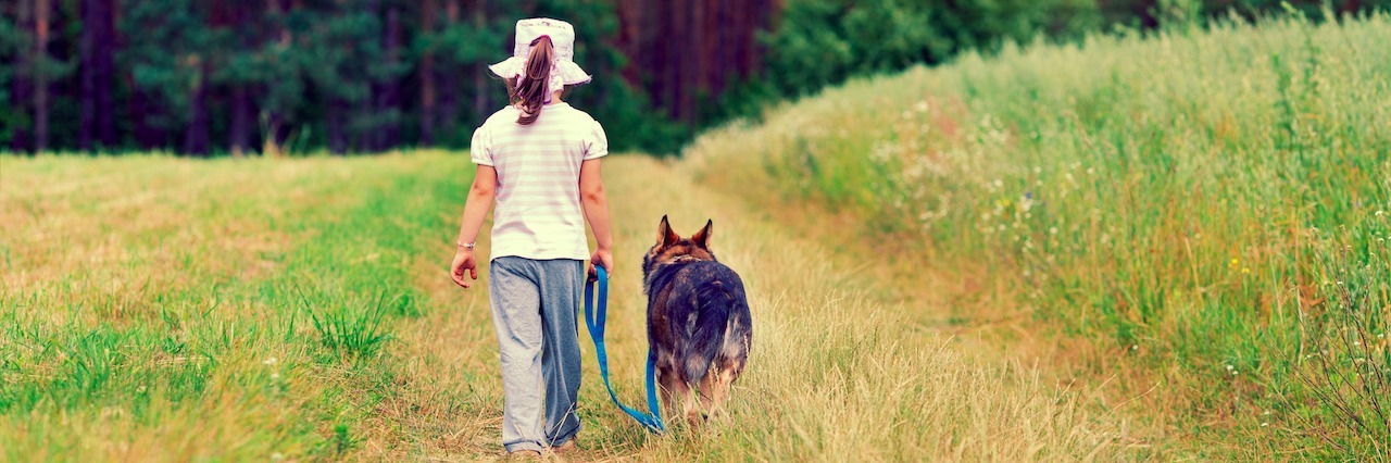 Woman With Borderline Personality Disorder Shares Bullying Story Little girl walking with a dog in a dirt road