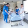 emergency room doctors wheeling a patient down a hallway on a gurney