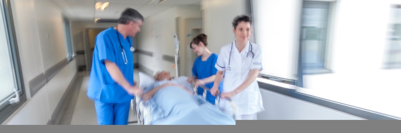 My First Experience With Hemiplegic Migraines emergency room doctors wheeling a patient down a hallway on a gurney