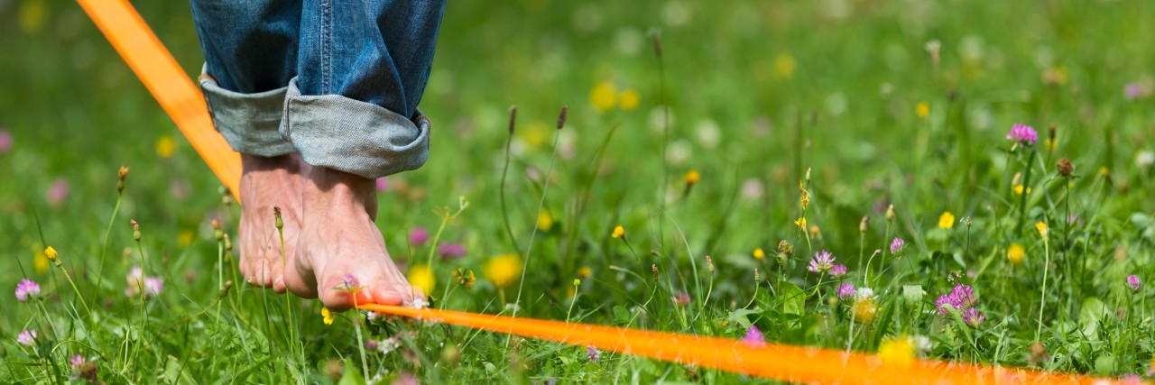 Finding Balance in My Mental Illness Recovery Guy practicing slack line in the city park.