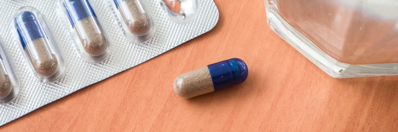 Taking Antidepressants as a Special Needs Parent medicine tablets and water glass on a table