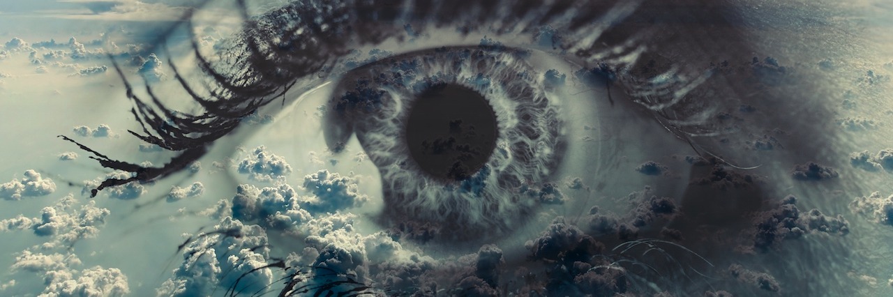 Woman eye on the background of clouds.