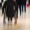 Rear view of person in wheelchair in public place in blured motion