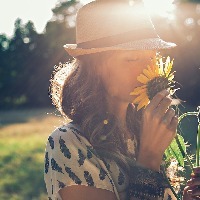 A girl smelling a sunflower.