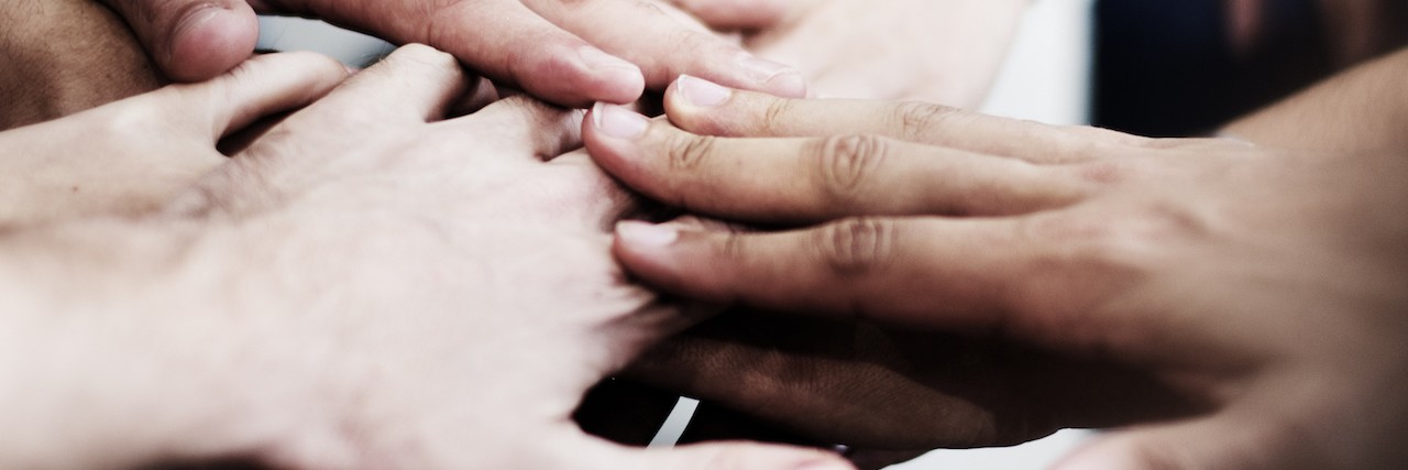 a group of people with their hands together.