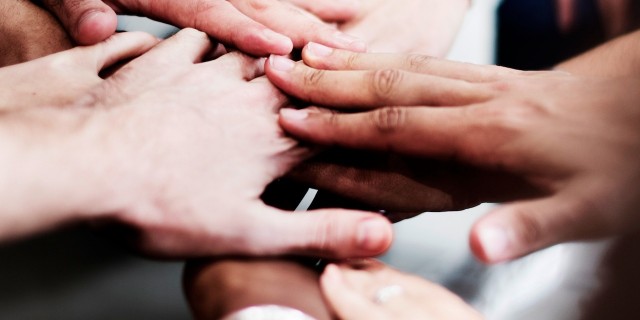 a group of people with their hands together.