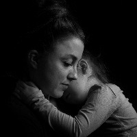 Black and white Picture of a child hugging her mother.Silhuette picture.