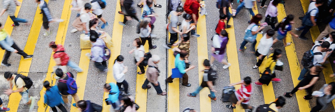 The Real Dangers of 'Othering' People With Mental Illness a group of people walking across the street