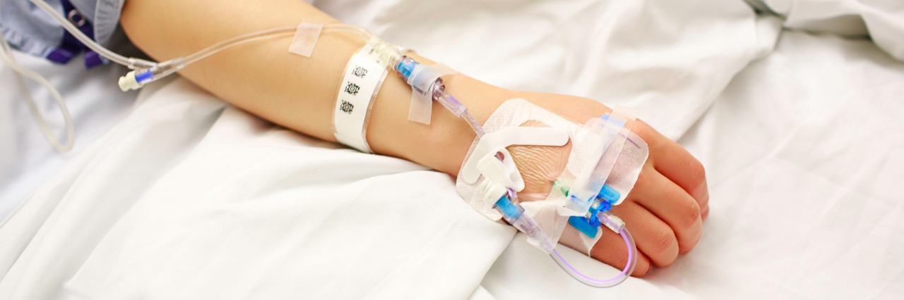 Patient with IV lines lying in hospital bed