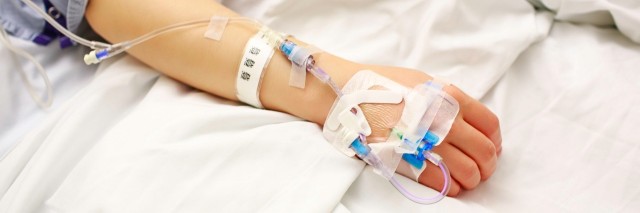 Patient with IV lines lying in hospital bed