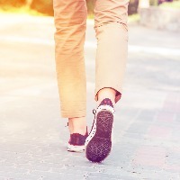legs walking down street wearing pants and sneakers