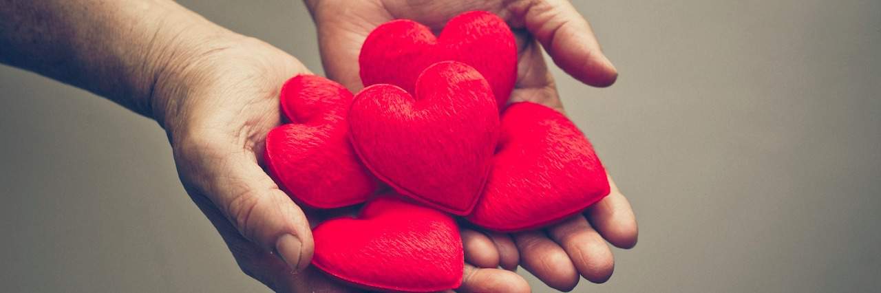 How to Support a Loved One Who's Lost Someone to Suicide A man holding hearts