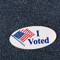closeup of an american i voted sticker placed on a navy shirt
