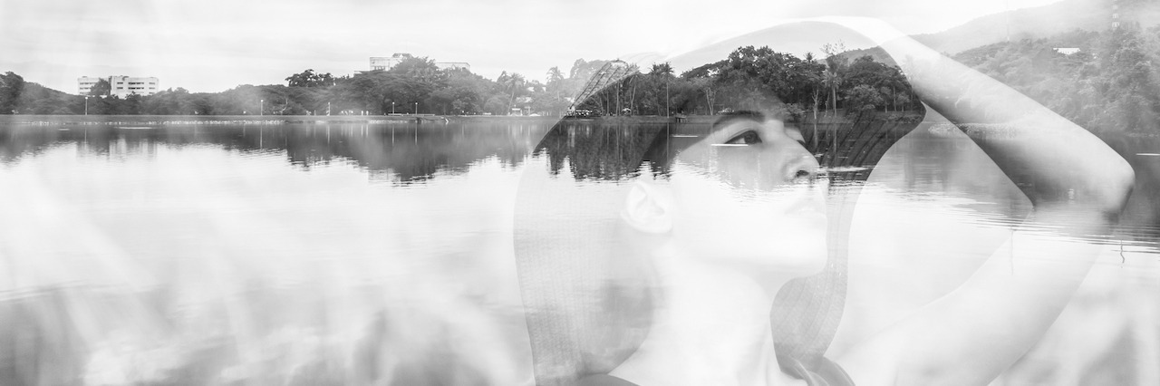 Experiencing Moments of Happiness in Depression a woman in a hat looking up in front of water