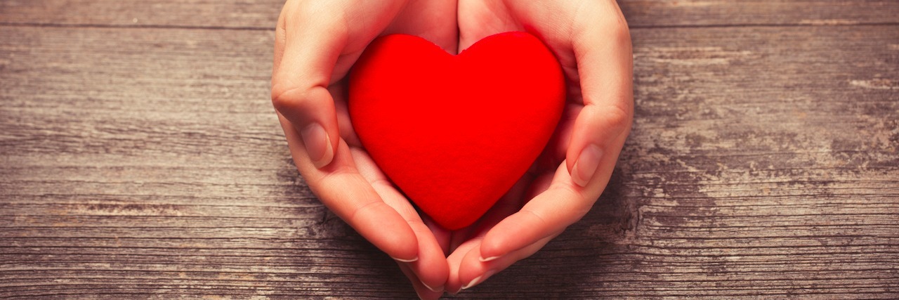 What a Person With a Mental Illness Needs From Someone Who Loves Them a woman holding a toy heart