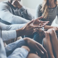 a group of people sitting in a circle, talking