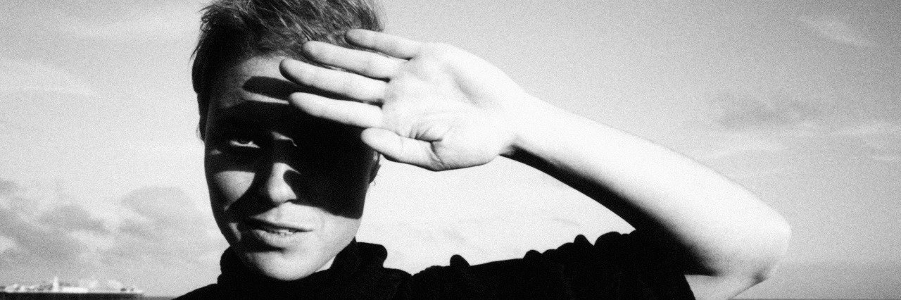 Why I Write About Depression, Even When I'm Struggling Woman standing on beach