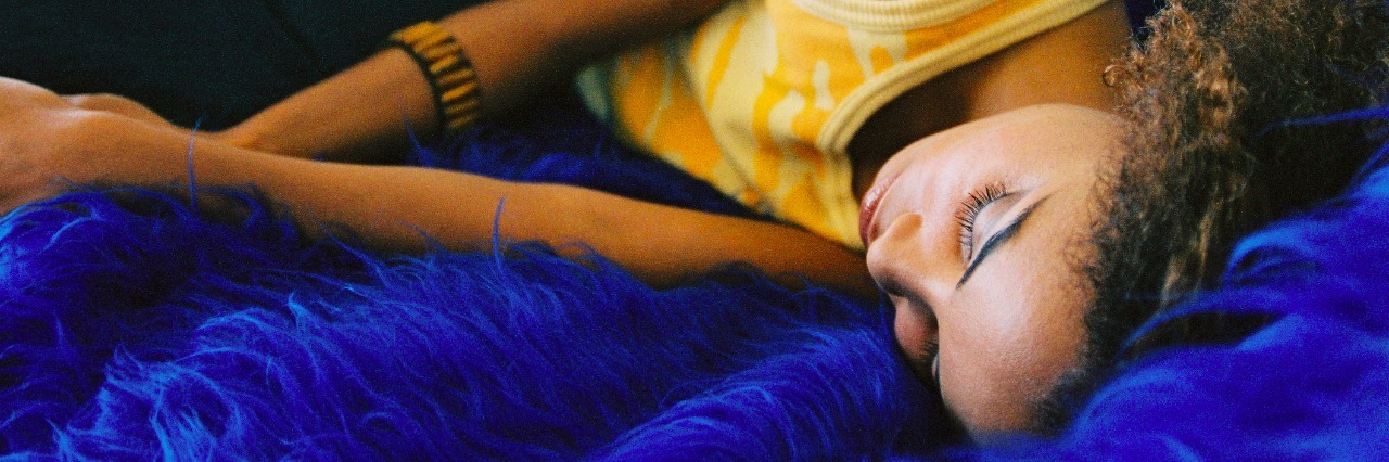 Learning to Live With the Symptoms of Hashimoto's Thyroiditis a young woman sleeping on a couch