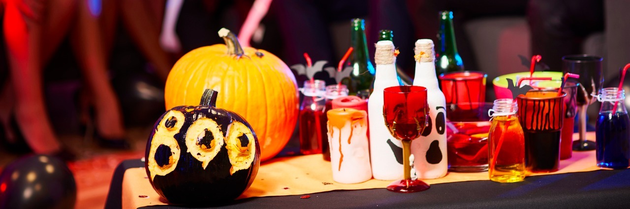 table at party with pumpkin and spooky drinks