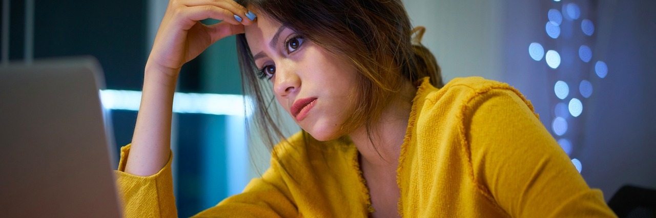 Tips for Managing Stressful Times for a Parent With Bipolar Disorder A woman on her laptop looking stressed