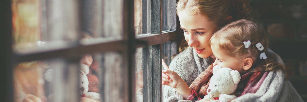 Parenting a Nonverbal Child With Cri Du Chat Syndrome: What to Know family mother and child daughter keep warm and look out the window on a rainy autumn day