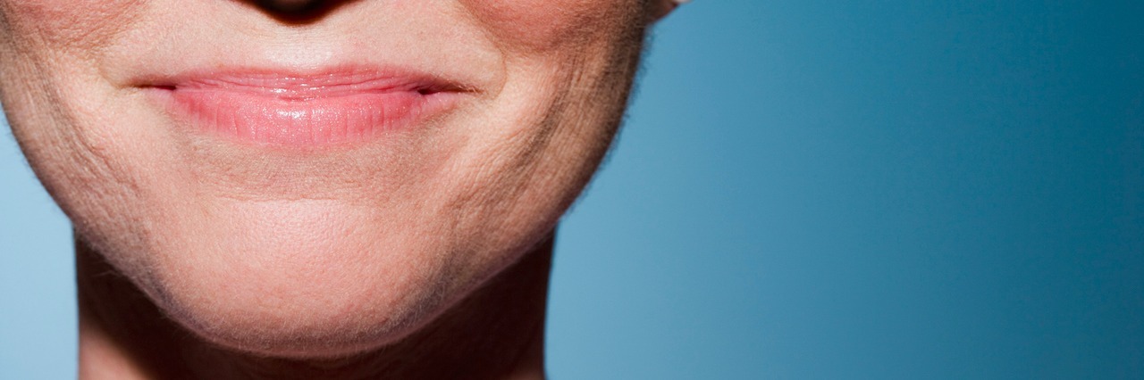 Societal Misconceptions About Happiness and Depression A woman smiling with her mouth closed