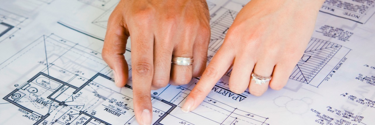 Couple pointing to blueprints