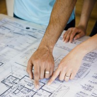 Couple pointing to blueprints