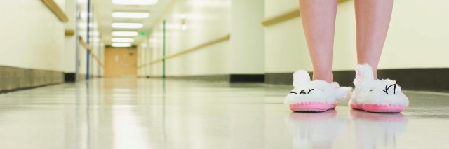 patient in slippers standing in hospital hallway