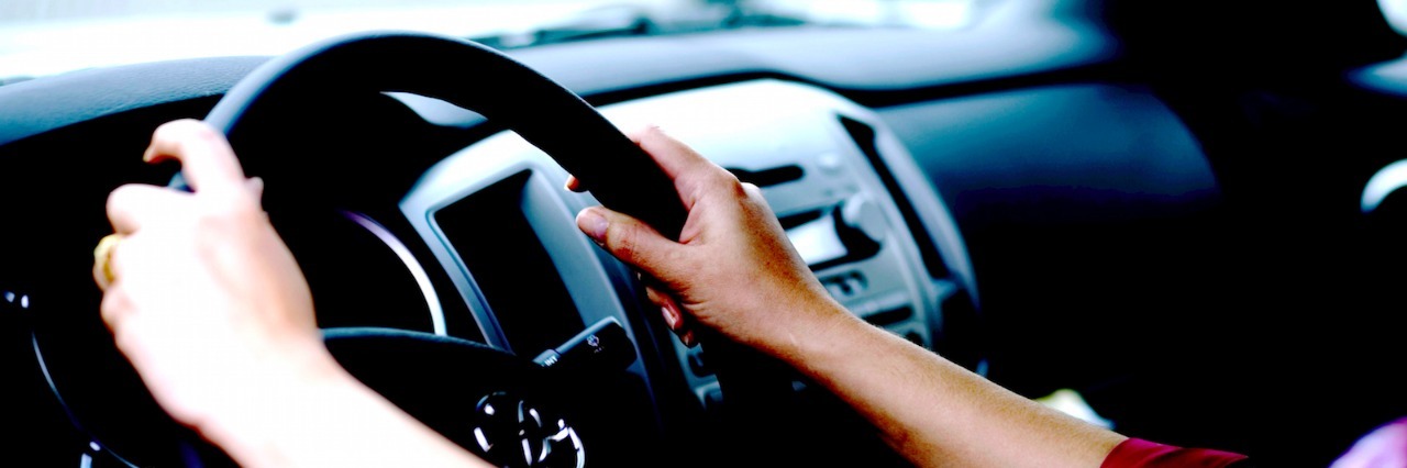 Woman's hands on car steering wheel
