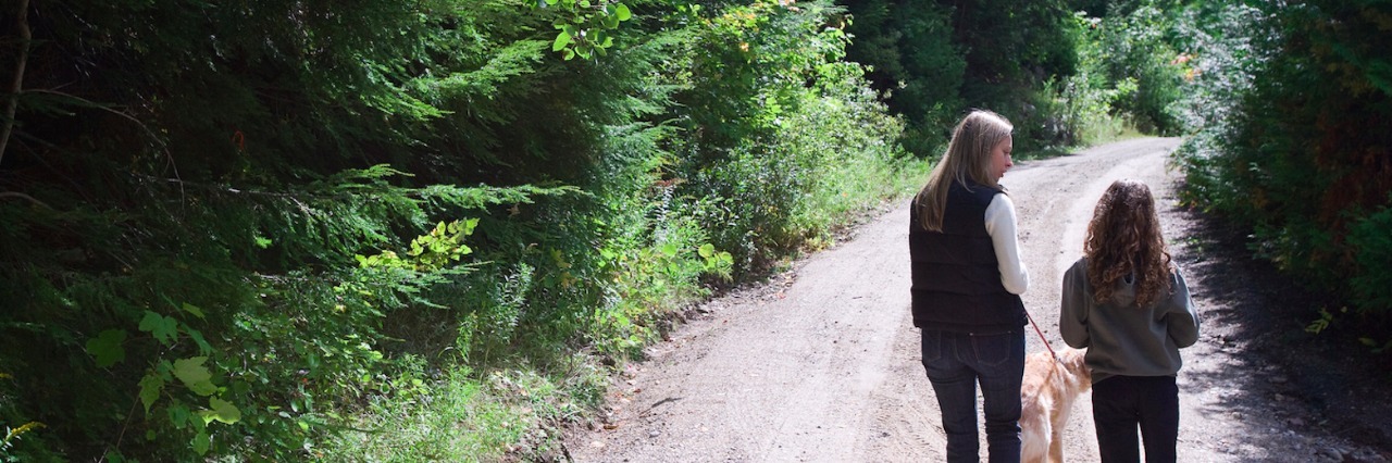 My Response to 'What Does ADHD Mean?' After My Child's ADHD Diagnosis Mother and daughter walking dog on road through forest