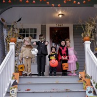 Five children standing on porch, wearing Halloween costumes, portrait
