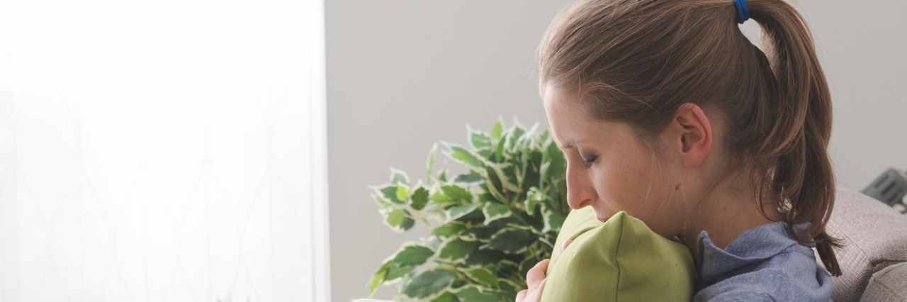 Why It’s OK to Say I Am Having a Bad Day Lonely depressed woman at home, she is sitting on the sofa and hugging a pillow